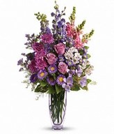 Lovely lavender roses, alstroemeria, larkspur, freesia, matsumoto asters and limonium are joined by light pink snapdragons, purple monte cassino asters and statice.