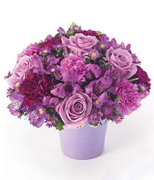 Arrangement of purple and lavender roses, carnations in a purple cache pot