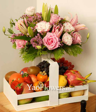 Pink Roses, Pink Lily And Wax Flowers With A Tray Of Assorted Fruits