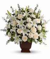 arrangement of creme roses, white oriental lilies, carnations, eucalyptus and more