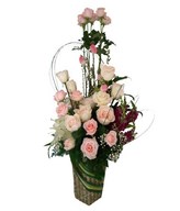 White and soft pink roses, casablanca lily and filler in container